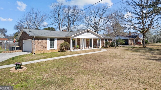 view of front facade with a front yard, fence, an attached garage, a chimney, and brick siding