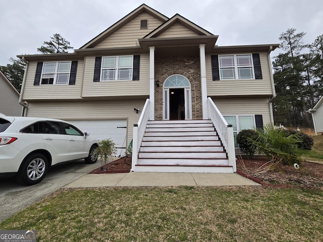 split foyer home with a garage, brick siding, and concrete driveway