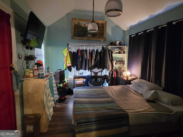 bedroom with lofted ceiling and wood finished floors