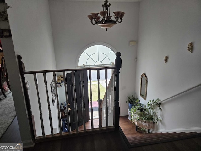 stairway featuring an inviting chandelier, a water view, and a towering ceiling