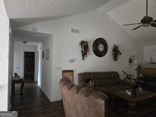 living room featuring dark wood-style flooring, attic access, visible vents, and lofted ceiling