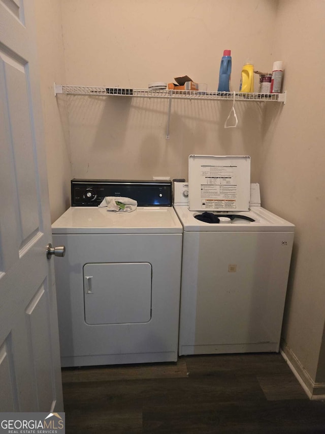 washroom with laundry area, washer and dryer, and dark wood-type flooring