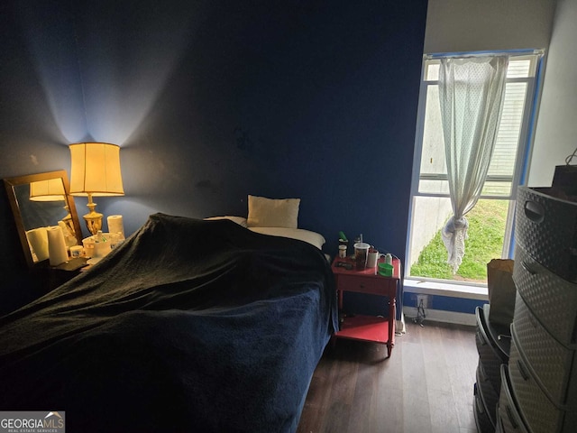 bedroom featuring baseboards and wood finished floors