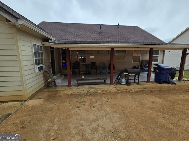 rear view of property with a patio area and a shingled roof