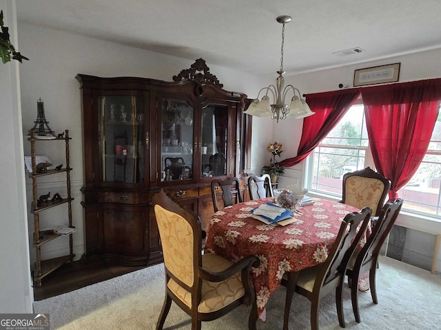 dining room with visible vents, light colored carpet, and an inviting chandelier