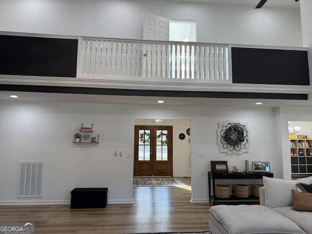 entrance foyer featuring visible vents, a high ceiling, a ceiling fan, wood finished floors, and baseboards