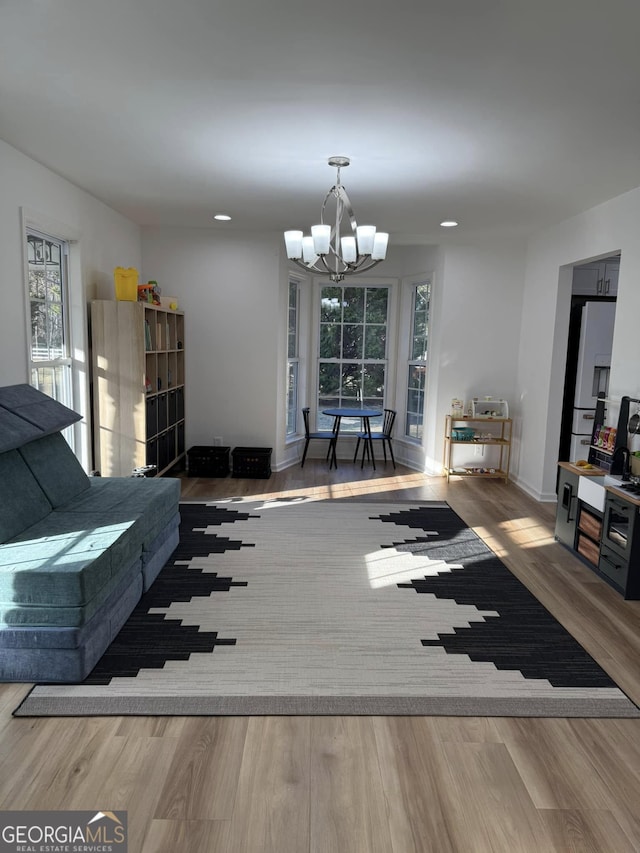 unfurnished dining area with baseboards, recessed lighting, wood finished floors, and an inviting chandelier