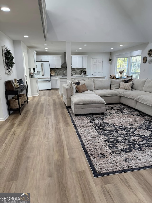 living room with light wood-style flooring and recessed lighting