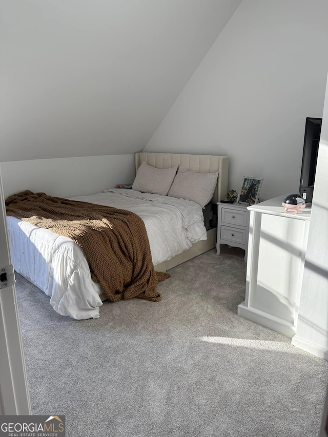 bedroom featuring light carpet and vaulted ceiling