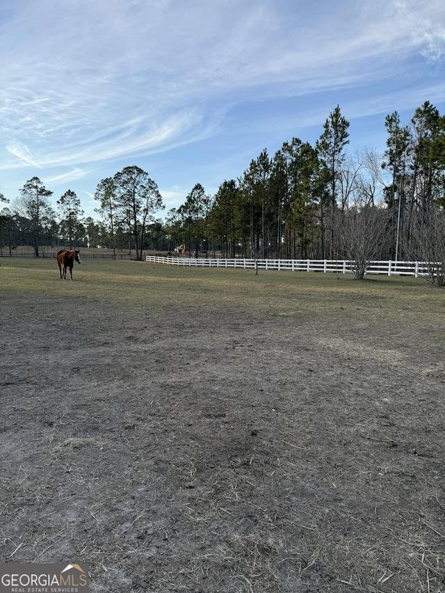 view of yard with a rural view and fence