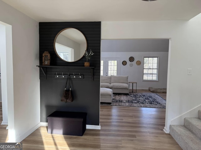 living area with stairway, baseboards, and wood finished floors