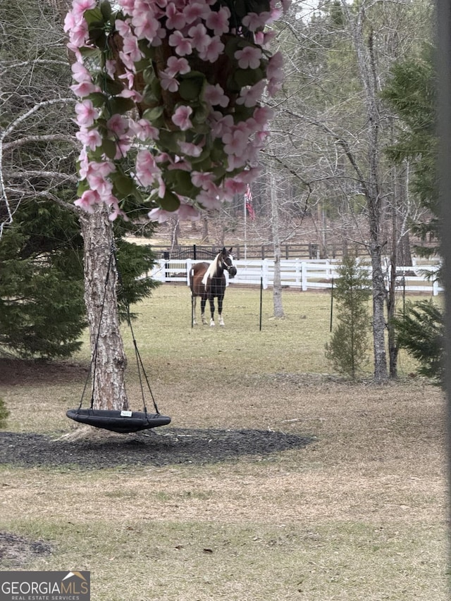 view of property's community featuring a yard and fence