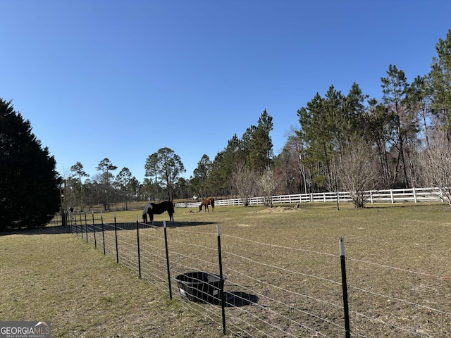 view of yard with a rural view and fence