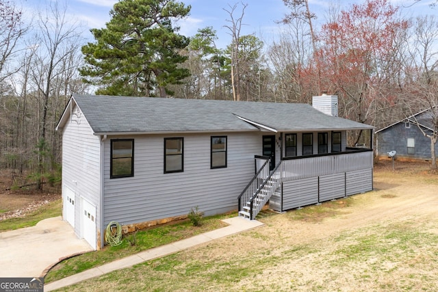 view of front of home with a garage, driveway, a shingled roof, a chimney, and stairs