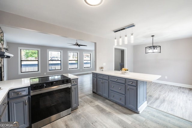 kitchen with electric stove, light countertops, and a healthy amount of sunlight