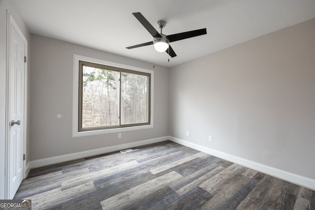 unfurnished bedroom featuring ceiling fan, wood finished floors, visible vents, and baseboards