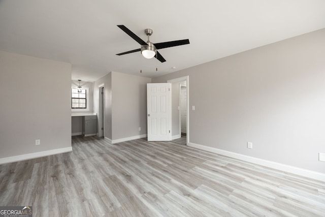 unfurnished bedroom featuring a ceiling fan, light wood finished floors, baseboards, and ensuite bathroom