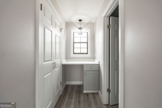 hall with baseboards and wood finished floors