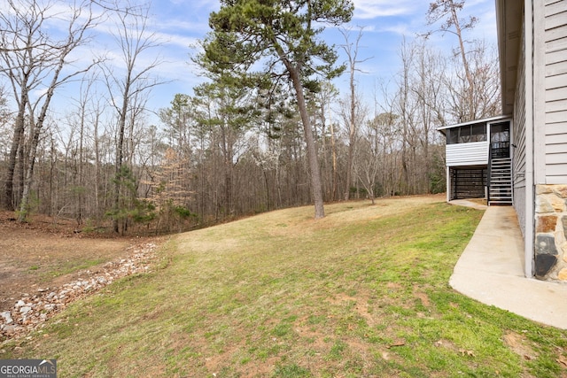 view of yard featuring stairway and a sunroom