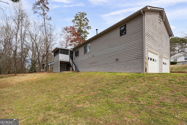 view of home's exterior featuring a garage, a sunroom, a yard, and stairs