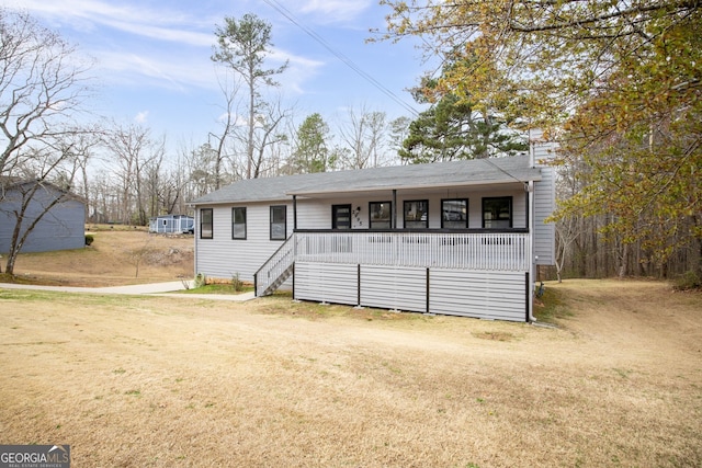 view of front facade featuring a chimney, dirt driveway, a front lawn, and a porch