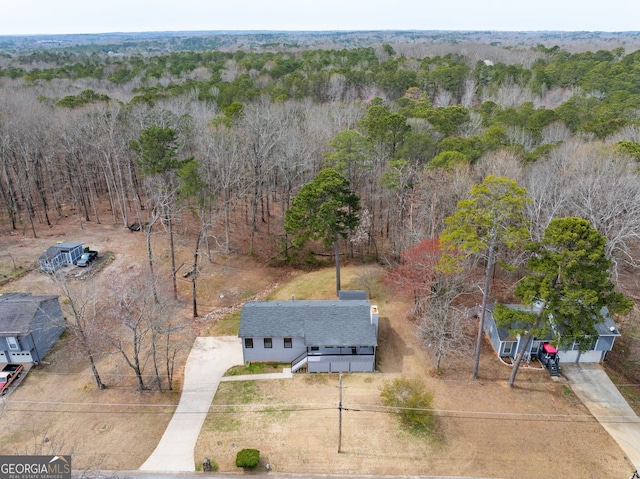 bird's eye view with a wooded view