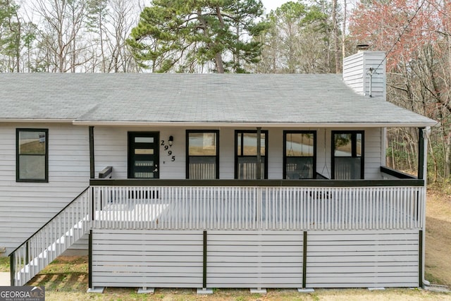 view of front of property with covered porch, stairway, and a chimney