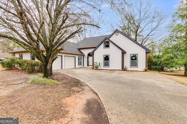 view of front of house featuring roof with shingles, driveway, and an attached garage