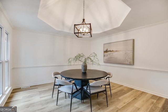 dining area featuring visible vents, crown molding, baseboards, and wood finished floors