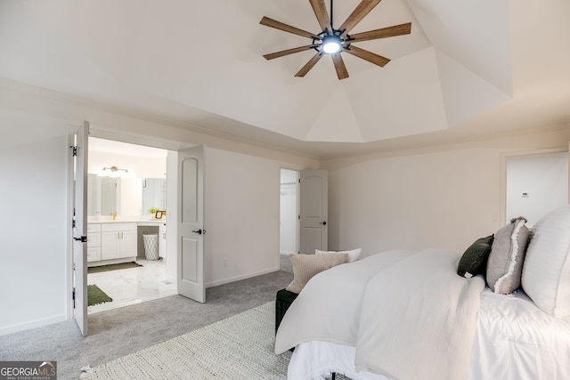 bedroom featuring baseboards, a ceiling fan, light colored carpet, lofted ceiling, and ensuite bath