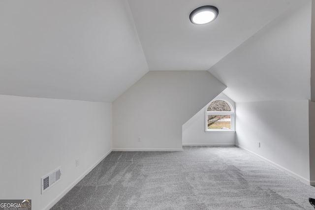 bonus room with lofted ceiling, baseboards, visible vents, and carpet flooring