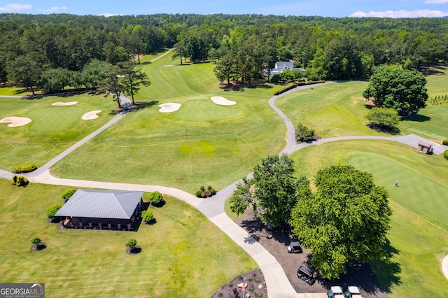 birds eye view of property with view of golf course and a view of trees