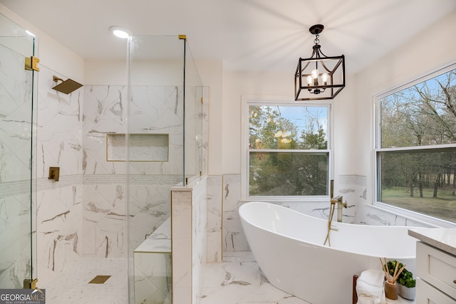 full bathroom featuring marble finish floor, wainscoting, a freestanding bath, and a marble finish shower