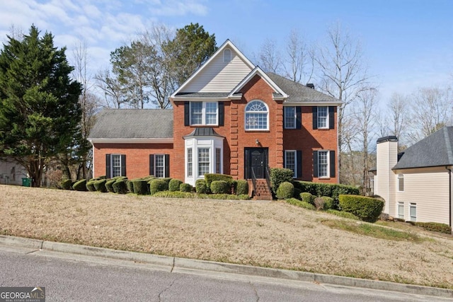 colonial-style house featuring brick siding