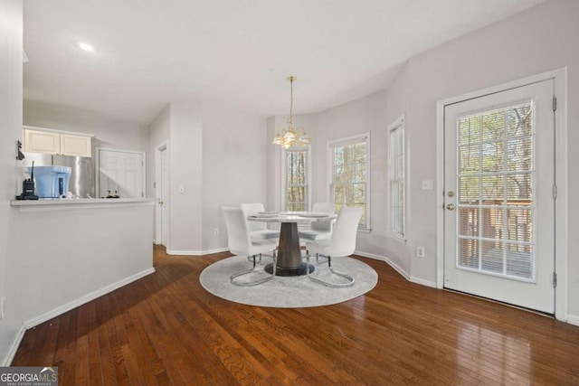 dining room with an inviting chandelier, wood-type flooring, and baseboards