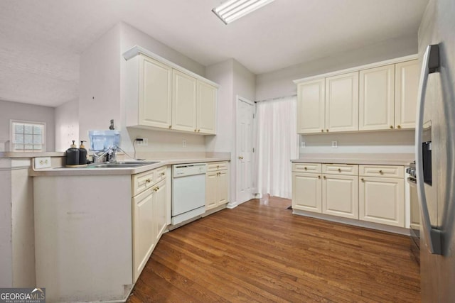 kitchen featuring a sink, wood finished floors, refrigerator with ice dispenser, light countertops, and dishwasher