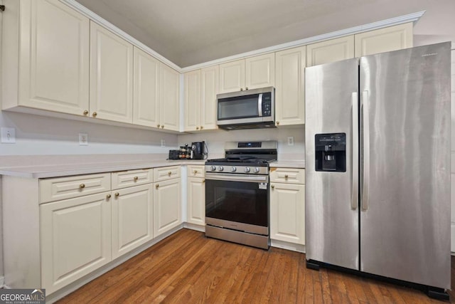kitchen with stainless steel appliances, white cabinets, light countertops, and dark wood-type flooring