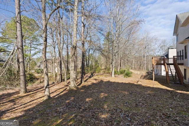view of yard with a deck and stairs