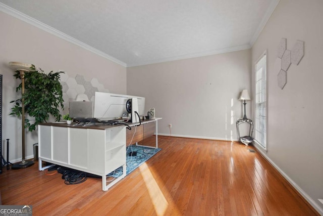 home office with baseboards, visible vents, ornamental molding, and hardwood / wood-style floors