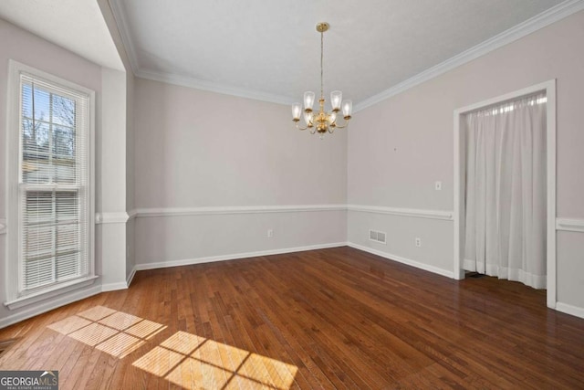 unfurnished dining area with crown molding, a notable chandelier, baseboards, and hardwood / wood-style flooring