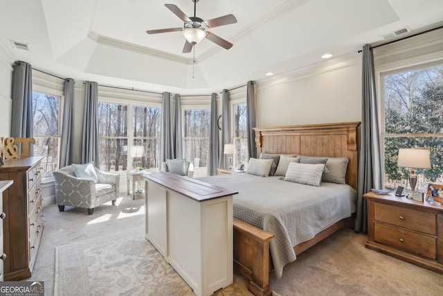 bedroom featuring a tray ceiling, light colored carpet, crown molding, and visible vents