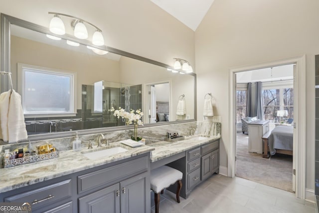 full bath with double vanity, ensuite bath, and a sink