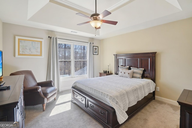bedroom with light colored carpet, a raised ceiling, baseboards, and visible vents