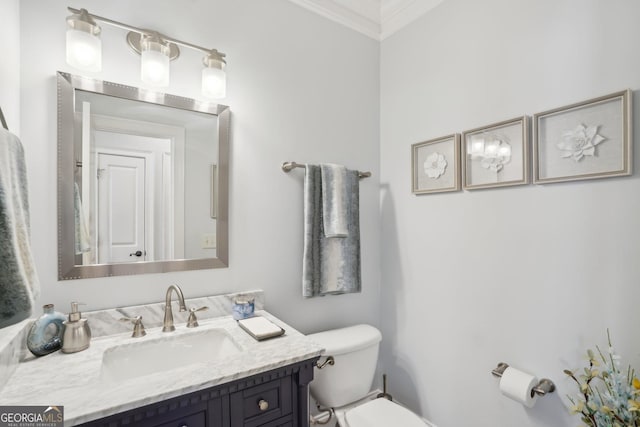 bathroom featuring toilet, vanity, and crown molding