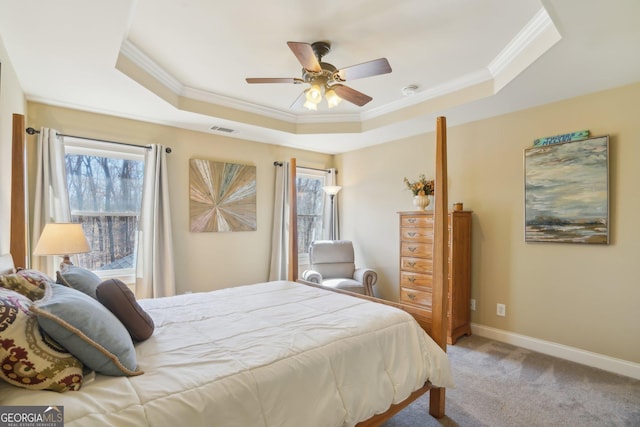 carpeted bedroom with crown molding, visible vents, and a raised ceiling