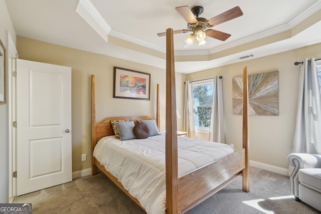 bedroom featuring a tray ceiling, crown molding, and carpet flooring