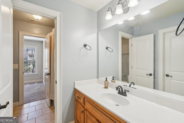 bathroom featuring vanity, baseboards, visible vents, and tile patterned floors