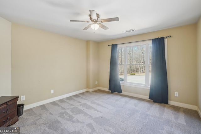 unfurnished room featuring carpet flooring, visible vents, baseboards, and ceiling fan