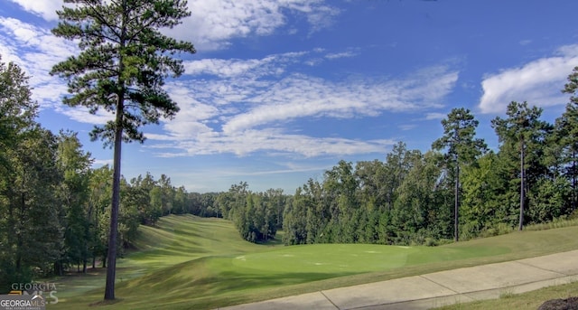 view of community with a yard and golf course view
