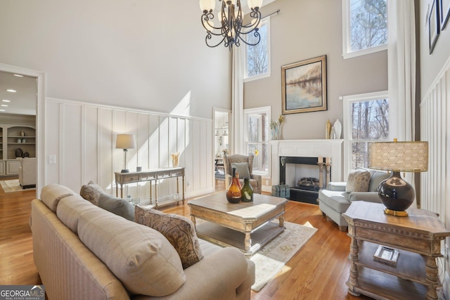 living area featuring a high ceiling, a notable chandelier, and plenty of natural light